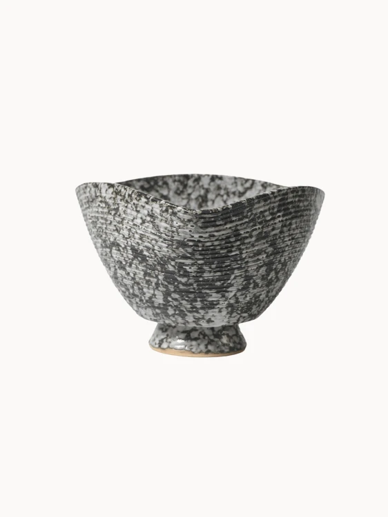 Ceramiczna miska, pokryta nakrapianą czarno-białą strukturą z poziomymi prążkami, na jednolitym białym tle. Miska ma unikalny, lekko kwadratowy, wygięty brzeg.