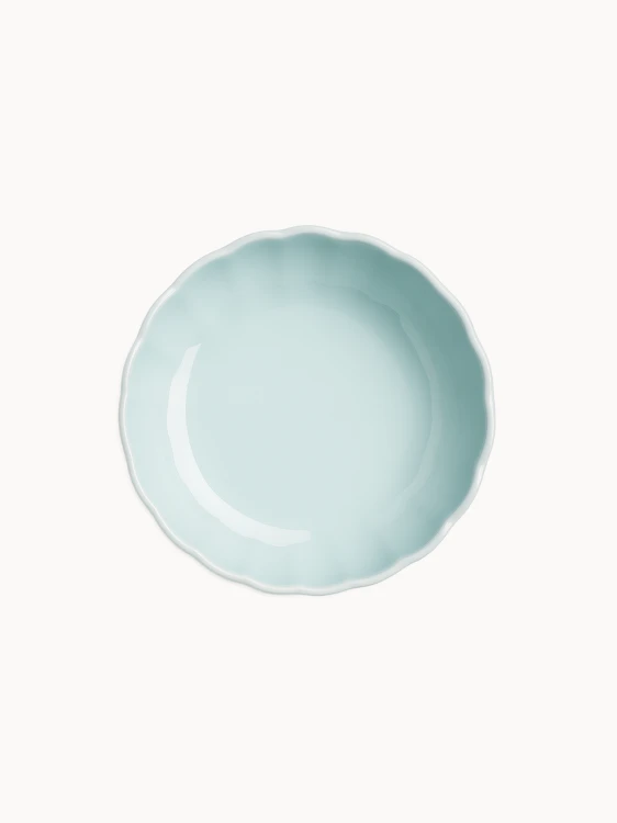 Zdjęcie z góry na pastelową jasnoniebieską ceramiczną paterę, na jednolitym białym tle.